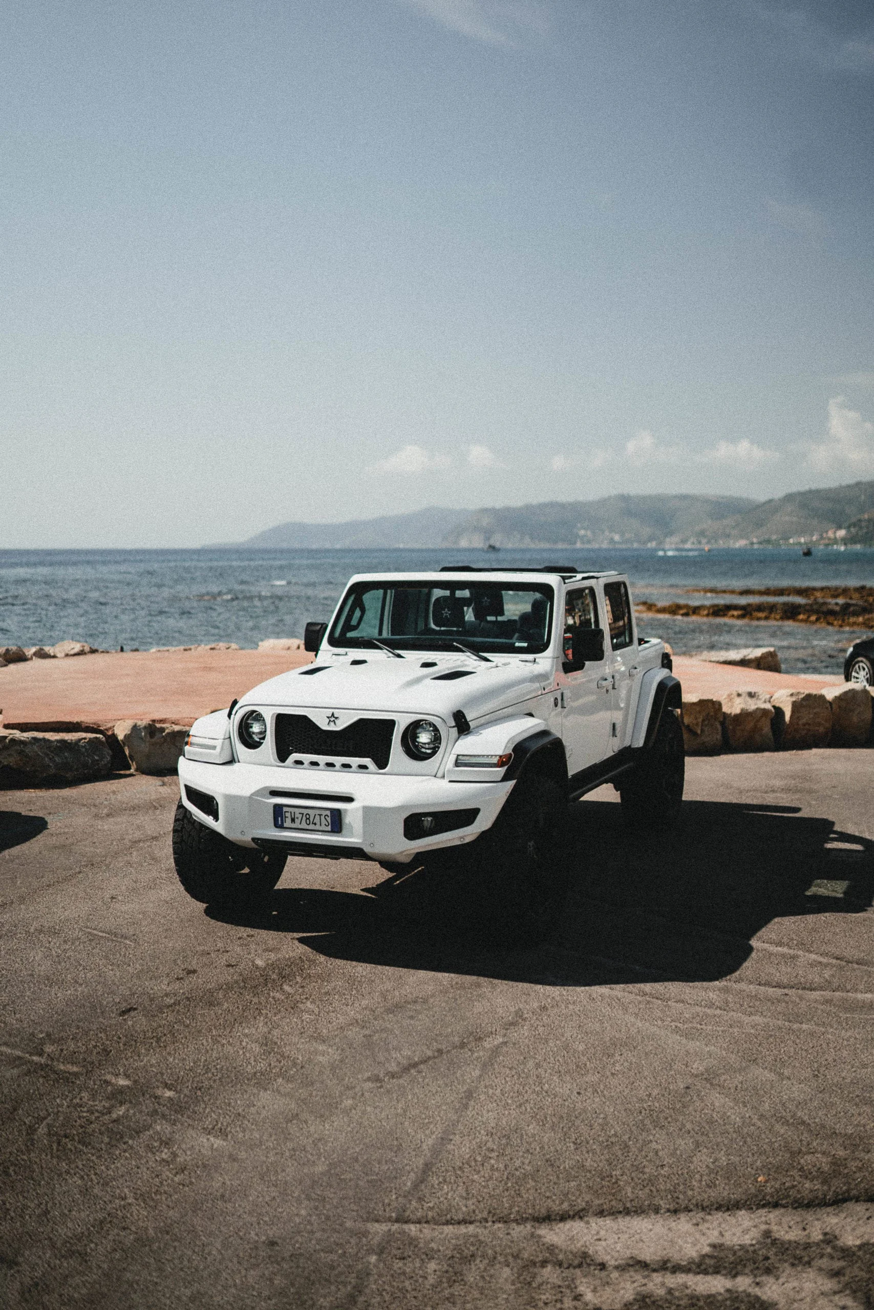 Primo_piano_frontale_di_Militem_Ferox_dalla_costa_sul_mare_in_amalfitana_Luxury_car_Lusso_e_design_Made_in_Italy_grinta_e_solidità_dei_fuoristrada_americani